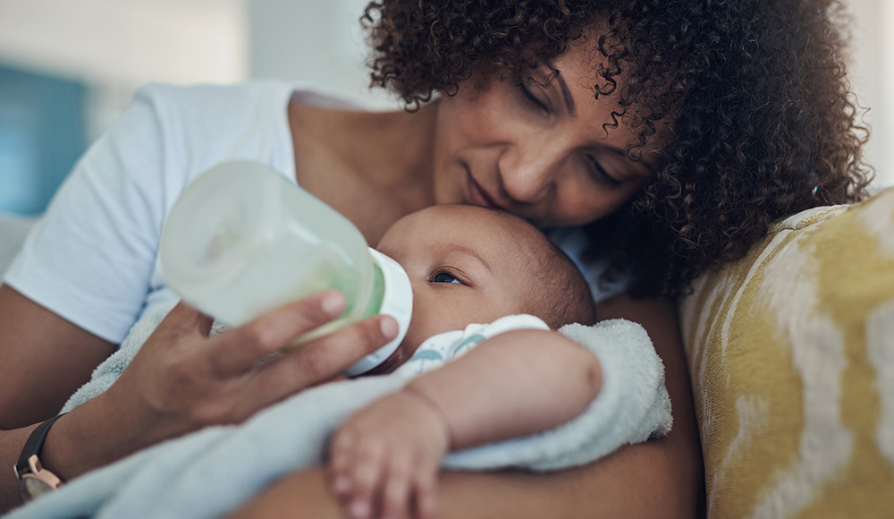 Maman qui donne le biberon à son bébé - dossier sur les familles monoparentales