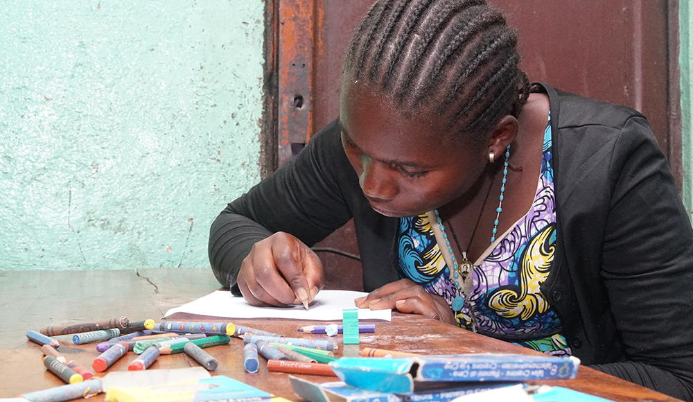 Jeune fille en train de dessiner en RDCongo