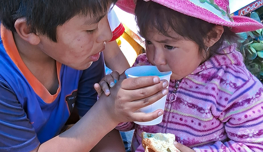Pérou aide alimentaire : deux enfants en train de boire et manger